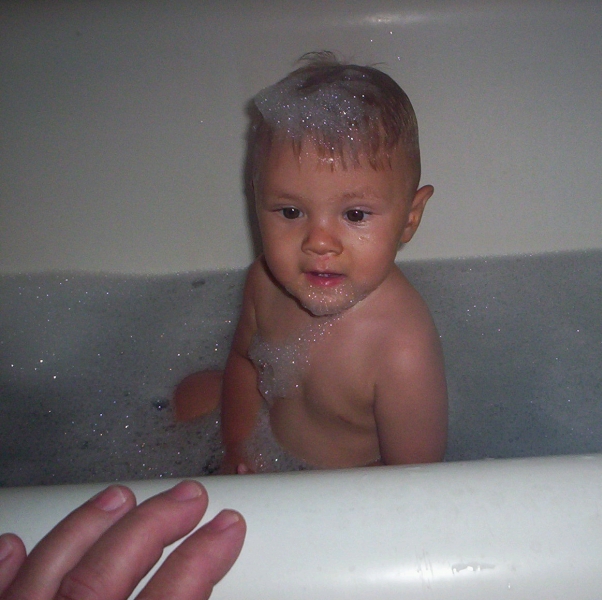 Sammy in bath with mommy's hand
